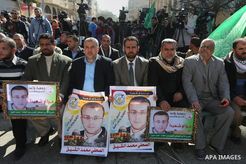 Palestinians hold posters during a protest in support of hunger striking Palestinian journalist Mohammed al-Qiq, in front of the Red cross office, Gaza city on February 14, 2016. The 33-year-old television reporter will...