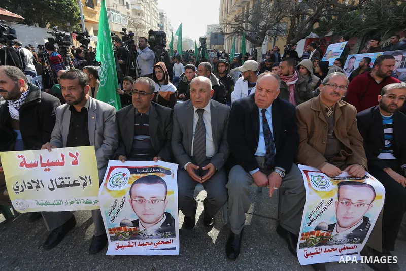 Palestinians hold posters during a protest in support of hunger striking Palestinian journalist Mohammed al-Qiq, in front of the Red cross office, Gaza city on February 14, 2016. The 33-year-old television reporter will...