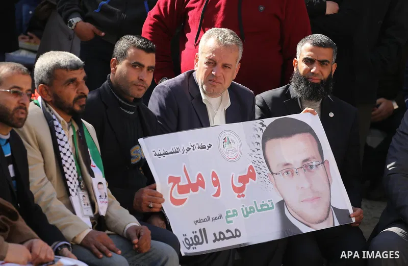 Palestinians hold posters during a protest in support of hunger striking Palestinian journalist Mohammed al-Qiq, in front of the Red cross office, Gaza city on February 14, 2016. The 33-year-old television reporter will...