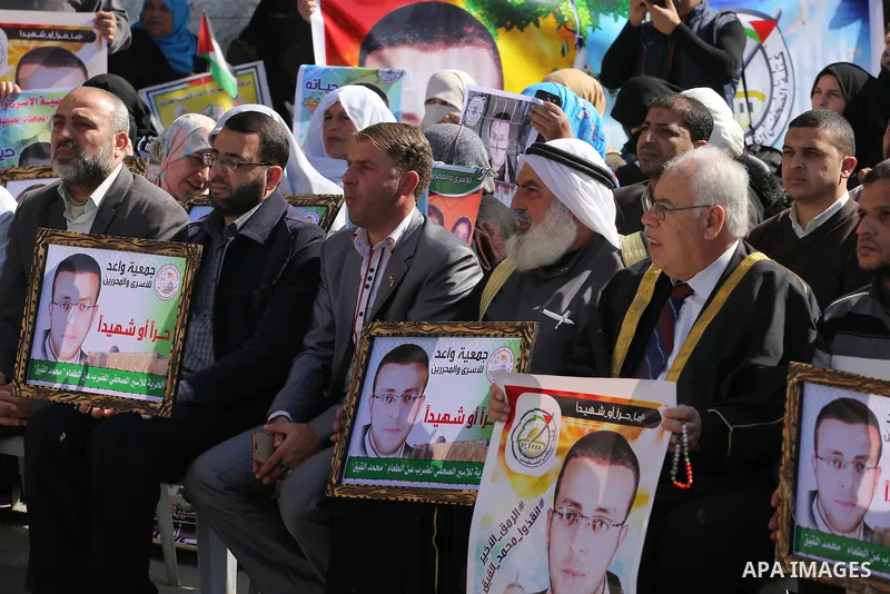 Palestinians hold posters during a protest in support of hunger striking Palestinian journalist Mohammed al-Qiq, in front of the Red cross office, Gaza city on February 14, 2016. The 33-year-old television reporter will...