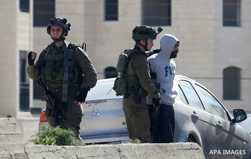 Israeli soldiers detain a Palestinian that they detain during clashes with stone-throwing Palestinian protesters in al-Amari refugee camp near the West Bank city of Ramallah, February 15, 2016. Photo by Shadi Hatem