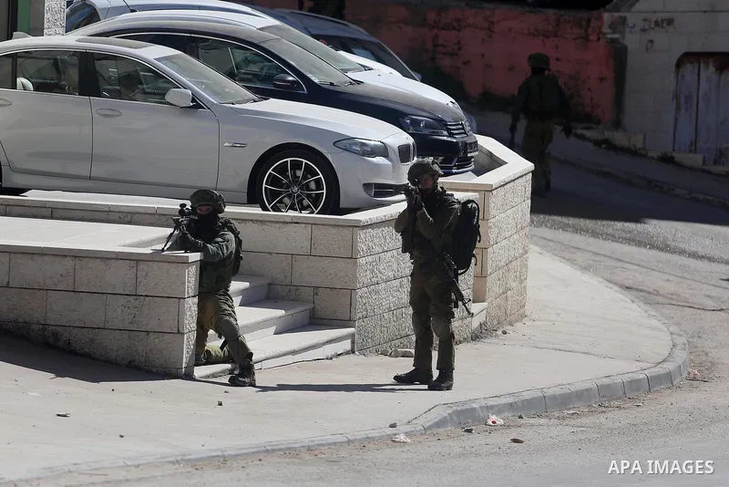 Israeli soldiers aim their weapon at Palestinian protesters during clashes in al-Amari refugee camp near the West Bank city of Ramallah February 15, 2016. Photo by Shadi Hatem
