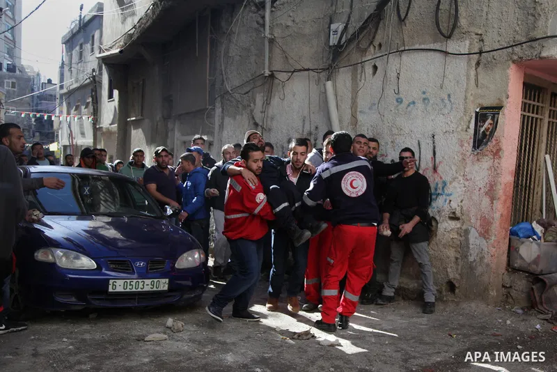 A Palestinian man, reported to be injured in the foot, is evacuated on February 15, 2016 on a street at the Amari refugee camp, near the West Bank city of Ramallah, during clashes that erupted after Israeli soldiers ente...