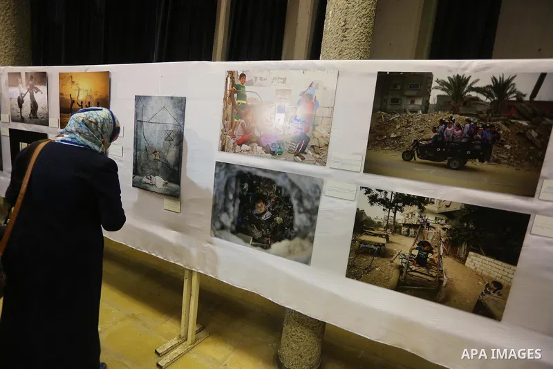 Palestinians attend a photo gallery organized by the Relief and Works Agency "UNRWA", in Gaza city on |Feb. 15, 2016. Photo by Mohammed Asad