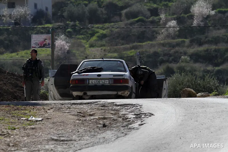 Israeli security forces inspect a car during clashes with Palestinian protesters in the village of Araka, West of Jenin in the Israeli occupied West Bank on February 15, 2016. Photo by Nedal Eshtayah