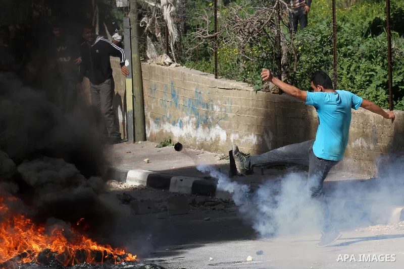 A Palestinian protester kicks a tear gas canister fired by Israeli security forces during clashes in the village of Araka, West of Jenin in the Israeli occupied West Bank on February 15, 2016. Photo by Nedal Eshtayah