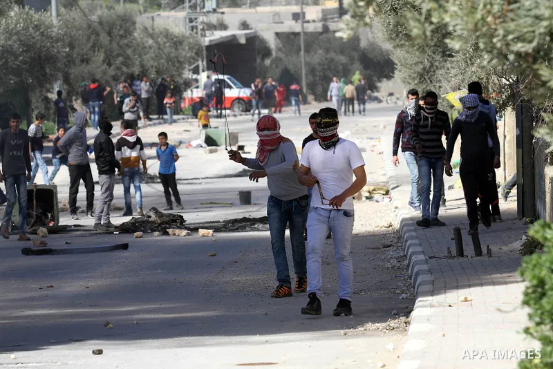 Palestinian protesters use a slingshot to hurl stones toward Israeli security forces during clashes in the village of Araka, West of Jenin in the Israeli occupied West Bank on February 15, 2016. Photo by Nedal Eshtayah