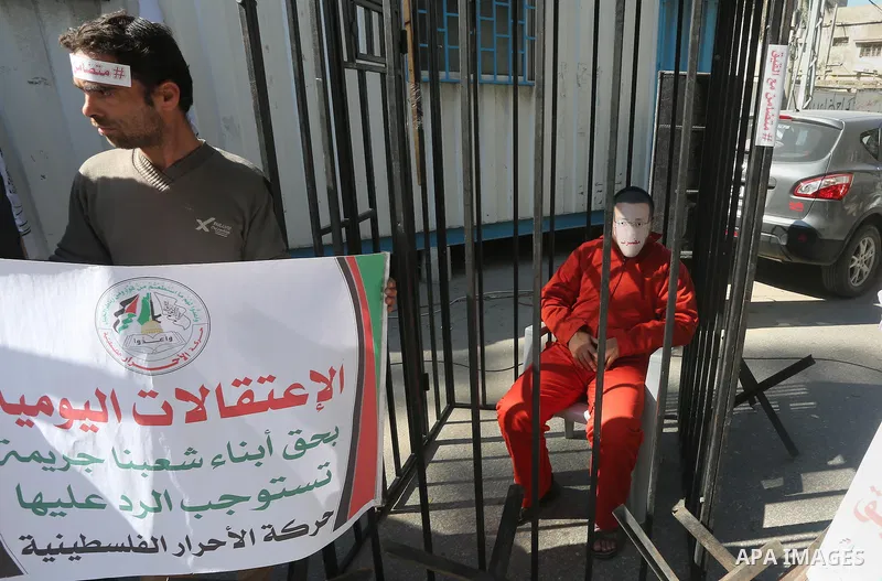 A Palestinian man wears a face covering depicting hunger striking Palestinian journalist Mohammed al-Qiq during a protest in Gaza city on February 17, 2016. Israel's top court rejected Qiq's request to be moved to the We...