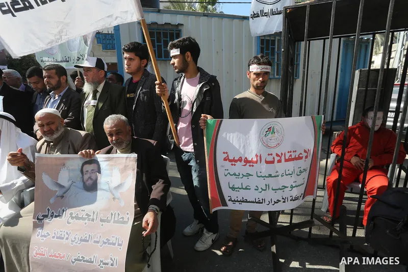 Palestinians hold posters during a protest in support of hunger striking Palestinian journalist Mohammed al-Qiq, in Gaza city on February 17, 2016. Israel's top court rejected Qiq's request to be moved to the West Bank f...