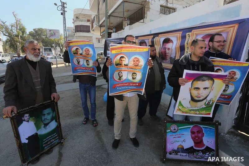 Relatives of four Palestinian men abducted by unidentified masked gunmen on August 19, hold their relatives' pictures during a protest demanding for their return, in Gaza city on February 17, 2016. Photo by Mohammed Asad