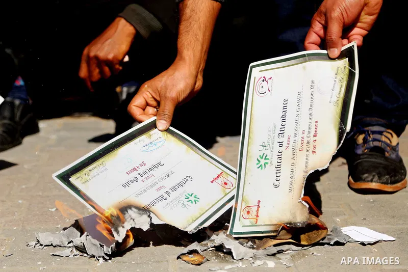 Egyptians burn their certificate of Master's and Ph.D. during a protest to demand jobs in front of the journalists syndicate, in Cairo, Egypt, on February 17, 2016. Photo by Alaa Elkassas
