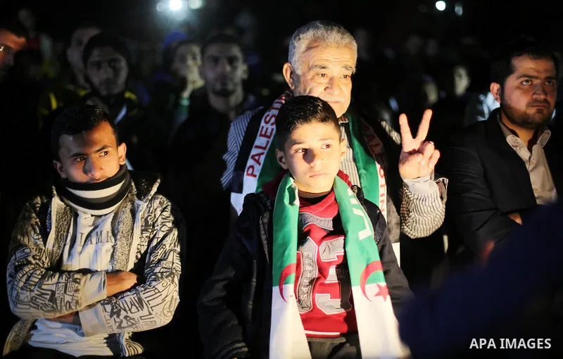 Palestinian fans watch on giant screens a friendly football match between Palestinian team and Algeria's team in Gaza city on Feb. 17, 2016. Photo by Mohammed Asad