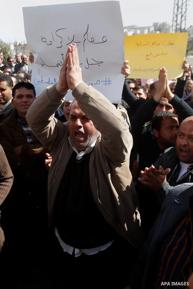 Palestinian teachers take part in a protest to demand their rights, in the West bank city of Hebron, on February 18, 2016. Photo by Wisam Hashlamoun