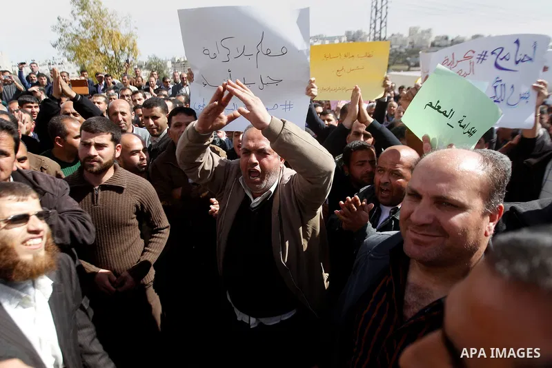 Palestinian teachers take part in a protest to demand their rights, in the West bank city of Hebron, on February 18, 2016. Photo by Wisam Hashlamoun