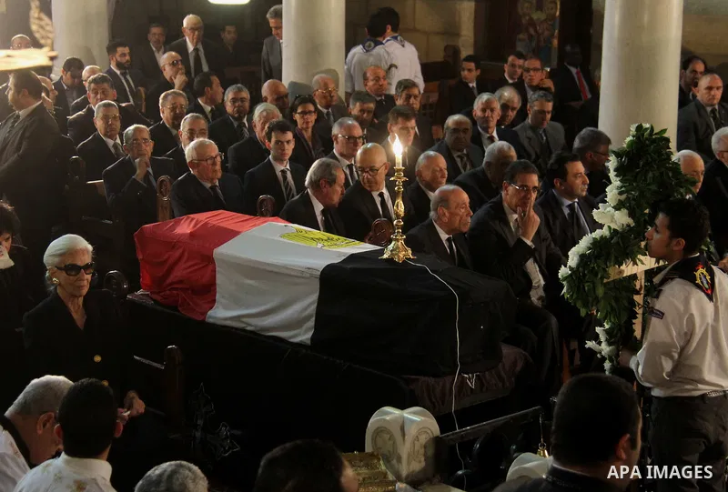 Leia Boutros-Ghali (L), the wife of former UN secretary-general Boutros Boutros-Ghali sits next to her husbands coffin draped in the Egyptian flag during his funeral at the St Peter and St Paul Coptic Orthodox church tha...
