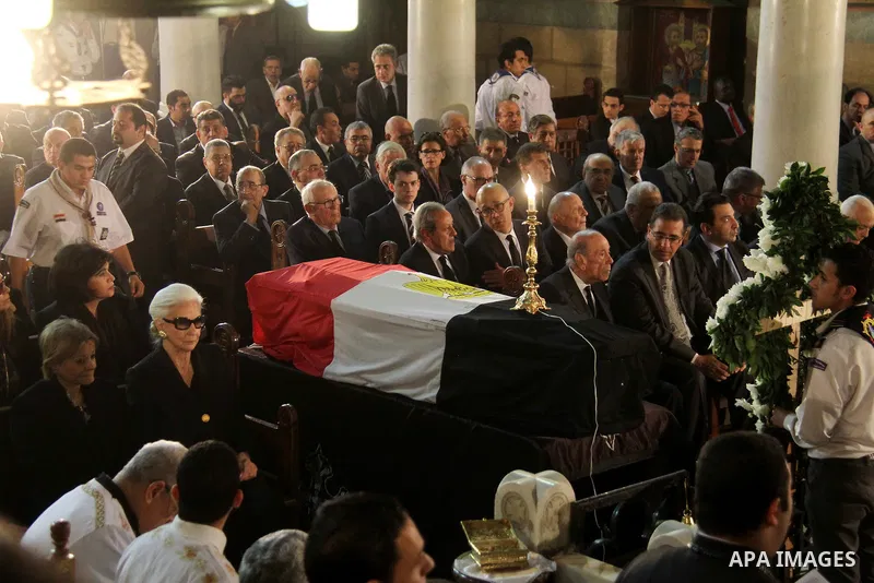 Leia Boutros-Ghali (L), the wife of former UN secretary-general Boutros Boutros-Ghali sits next to her husbands coffin draped in the Egyptian flag during his funeral at the St Peter and St Paul Coptic Orthodox church tha...
