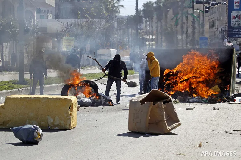 Palestinian protesters burn tires during clashes with Israeli security forces (unseen) to show solidarity with Mohammed al-Qiq a Palestinian prisoner on hunger strike, in the West bank city of Hebron on February 19, 2016...