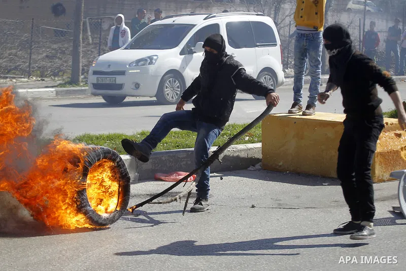 Palestinian protesters burn tires during clashes with Israeli security forces (unseen) to show solidarity with Mohammed al-Qiq a Palestinian prisoner on hunger strike, in the West bank city of Hebron on February 19, 2016...