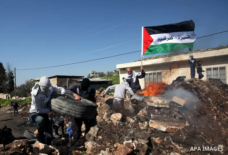 Palestinian protesters burn tires during clashes with Israeli security forces following a demonstration against the expropriation of Palestinian land by Israel on February 19, 2016 in the village of Kfar Qaddum, near Nab...