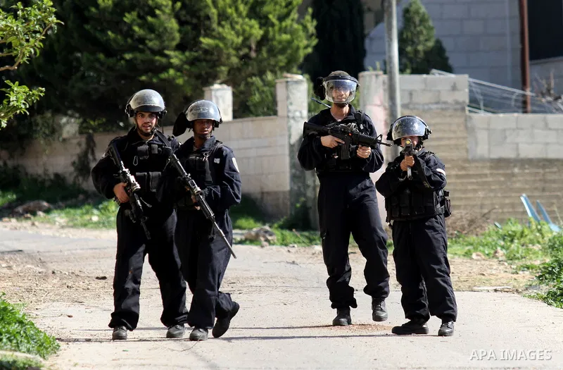 Israeli security forces aim their weapons towards Palestinian protesters during clashes following a demonstration against the expropriation of Palestinian land by Israel on February 19, 2016 in the village of Kfar Qaddum...