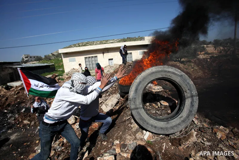 Palestinian protesters burn tires during clashes with Israeli security forces following a demonstration against the expropriation of Palestinian land by Israel on February 19, 2016 in the village of Kfar Qaddum, near Nab...