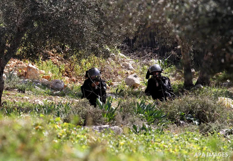 Israeli security forces aim their weapons towards Palestinian protesters during clashes following a demonstration against the expropriation of Palestinian land by Israel on February 19, 2016 in the village of Kfar Qaddum...