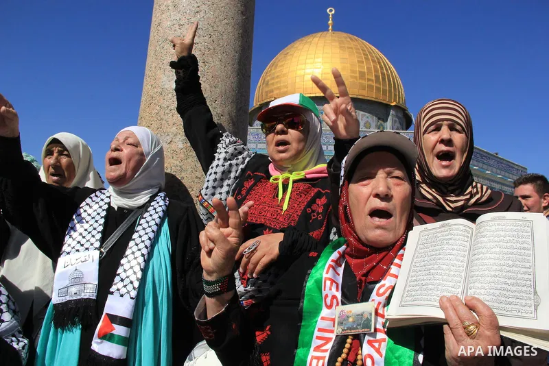 Palestinians hold posters bearing a portrait of Palestinian journalist Mohammed al-Qiq who is imprisoned in an Israeli jail during a protest in support of his hunger strike in front of Jerusalem's Dome of the Rock mosque...