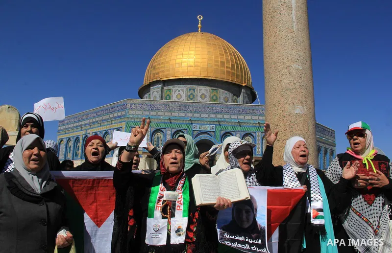 Palestinians hold posters bearing a portrait of Palestinian journalist Mohammed al-Qiq who is imprisoned in an Israeli jail during a protest in support of his hunger strike in front of Jerusalem's Dome of the Rock mosque...