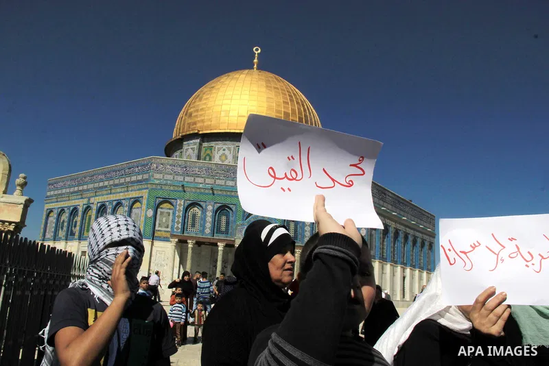 Palestinians hold posters bearing a portrait of Palestinian journalist Mohammed al-Qiq who is imprisoned in an Israeli jail during a protest in support of his hunger strike in front of Jerusalem's Dome of the Rock mosque...