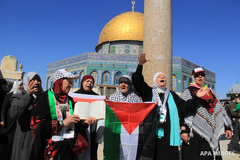 Palestinians hold posters bearing a portrait of Palestinian journalist Mohammed al-Qiq who is imprisoned in an Israeli jail during a protest in support of his hunger strike in front of Jerusalem's Dome of the Rock mosque...