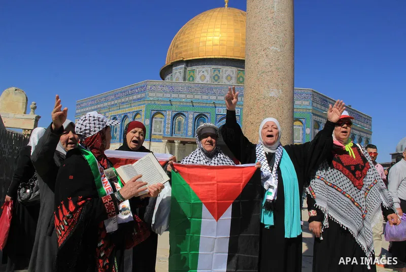 Palestinians hold posters bearing a portrait of Palestinian journalist Mohammed al-Qiq who is imprisoned in an Israeli jail during a protest in support of his hunger strike in front of Jerusalem's Dome of the Rock mosque...
