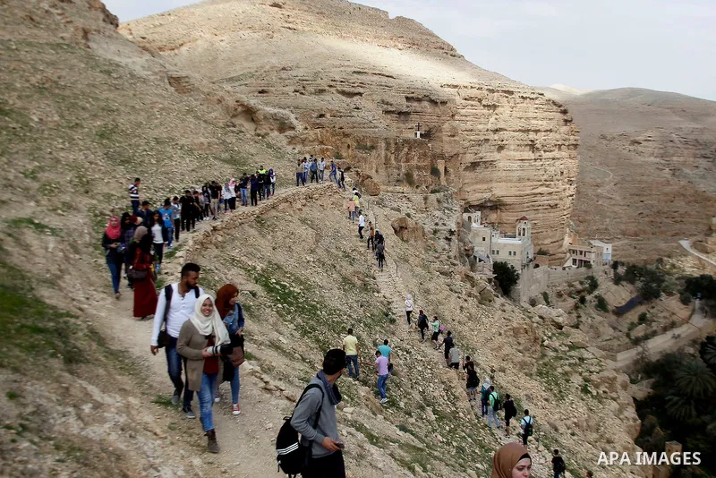 Palestinian youths walk on the mountains of Wadi Qelt, near the West Bank city of Jericho, on Feb 20, 2016. Wadi Qelt is a valley running west to east across the Judean desert in the West Bank, originating near Jerusalem...