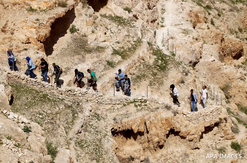 Palestinian youths walk on the mountains of Wadi Qelt, near the West Bank city of Jericho, on Feb 20, 2016. Wadi Qelt is a valley running west to east across the Judean desert in the West Bank, originating near Jerusalem...