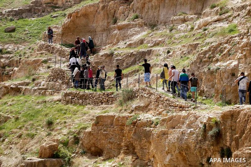 Palestinian youths walk on the mountains of Wadi Qelt, near the West Bank city of Jericho, on Feb 20, 2016. Wadi Qelt is a valley running west to east across the Judean desert in the West Bank, originating near Jerusalem...