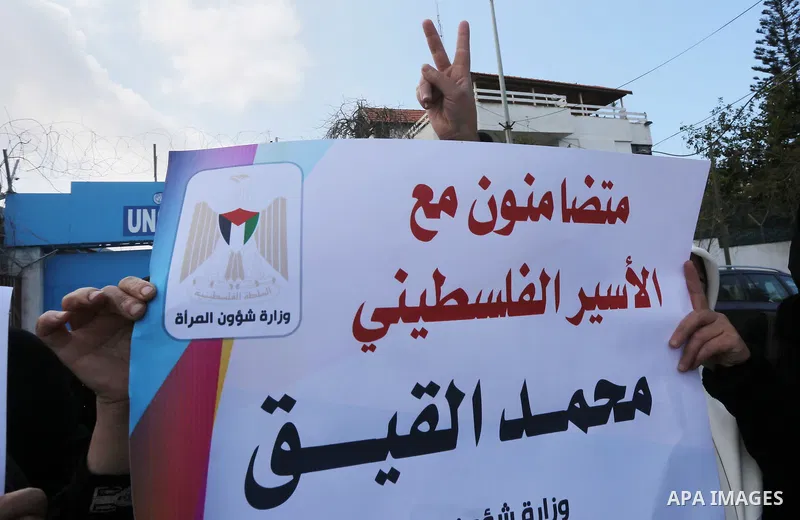 Palestinian women hold posters bearing a portrait of Palestinian journalist Mohammed al-Qiq who is imprisoned in an Israeli jail during a protest in support of his hunger strike in Gaza city on Feb. 21, 2016. Photo by Mo...