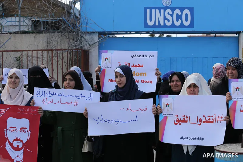 Palestinian women hold posters bearing a portrait of Palestinian journalist Mohammed al-Qiq who is imprisoned in an Israeli jail during a protest in support of his hunger strike in Gaza city on Feb. 21, 2016. Photo by Mo...