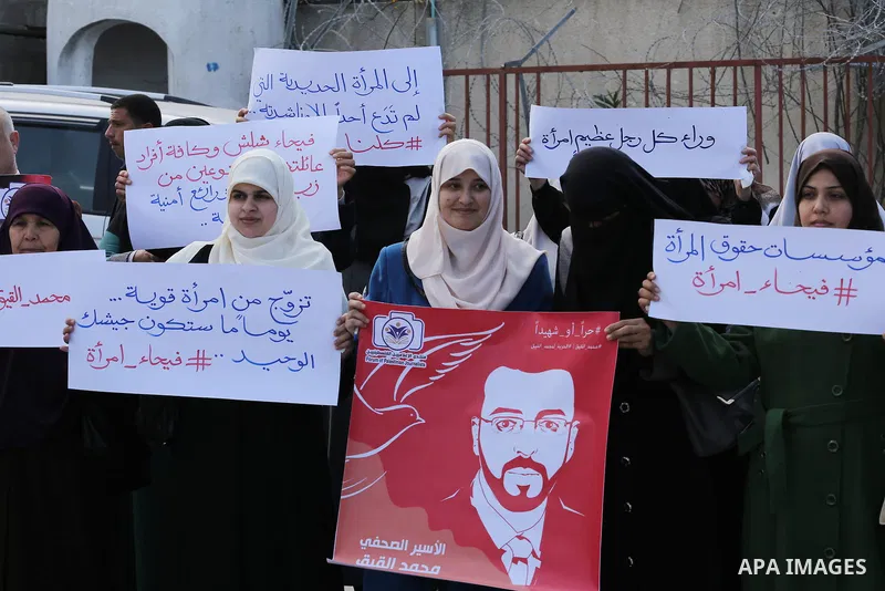 Palestinian women hold posters bearing a portrait of Palestinian journalist Mohammed al-Qiq who is imprisoned in an Israeli jail during a protest in support of his hunger strike in Gaza city on Feb. 21, 2016. Photo by Mo...