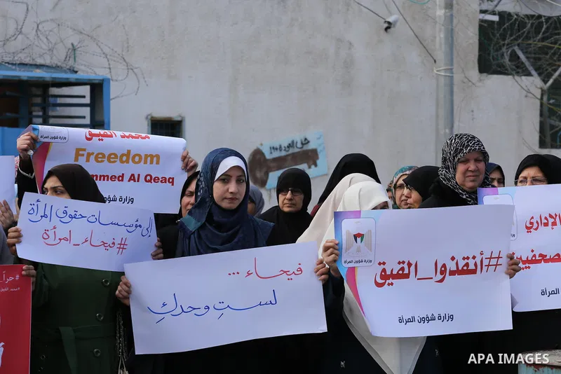 Palestinian women hold posters bearing a portrait of Palestinian journalist Mohammed al-Qiq who is imprisoned in an Israeli jail during a protest in support of his hunger strike in Gaza city on Feb. 21, 2016. Photo by Mo...
