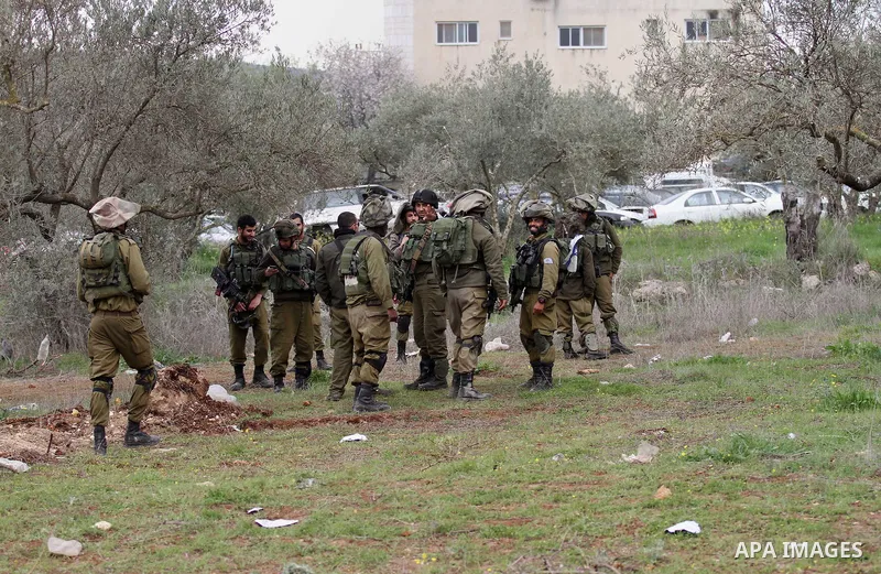 Israeli soldiers secure the scene after a Palestinian man who tried to stab an Israeli soldier before being shot dead, at the Bitot Junction south of Nablus in the northern occupied West Bank, on February 21, 2016. "A Pa...