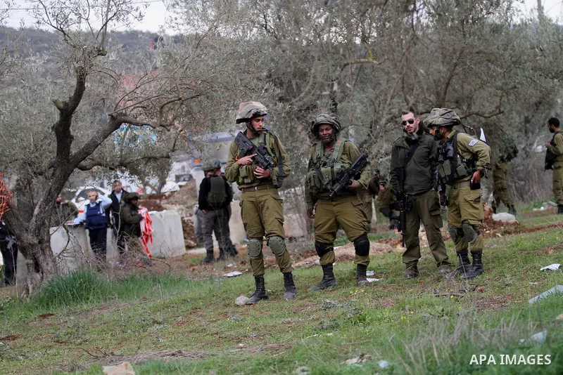 Israeli soldiers secure the scene after a Palestinian man who tried to stab an Israeli soldier before being shot dead, at the Bitot Junction south of Nablus in the northern occupied West Bank, on February 21, 2016. "A Pa...