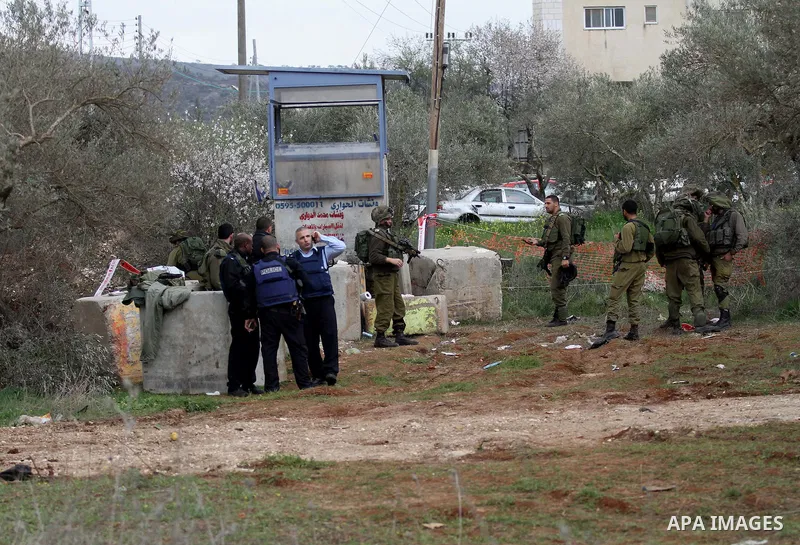 Israeli soldiers secure the scene after a Palestinian man who tried to stab an Israeli soldier before being shot dead, at the Bitot Junction south of Nablus in the northern occupied West Bank, on February 21, 2016. "A Pa...