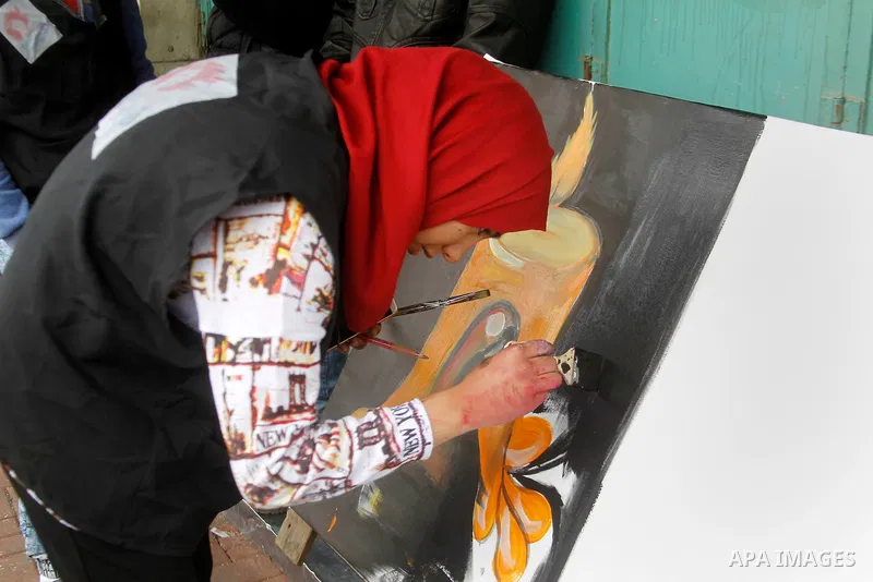 Palestinian youths paint a mural to mark the 22nd anniversary of the massacre of 29 Palestinian Muslim worshipers by Jewish extremist Baruch Goldstein at the Tomb of the Patriarchs on February 25, 1994 in the West Bank c...
