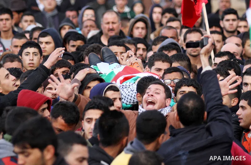 Mourners carry the the body of Palestinian teenager Qusay Abo Alrob, 16, whom the Israeli military said was shot dead by Israeli troops after he tried to stab a soldier on Sunday, during his funeral in the West Bank town...