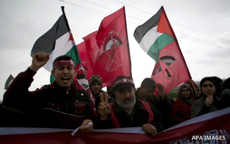Palestinian supporters of the Democratic Front for the Liberation of Palestine (DFLP) shout slogans and hold flags of the movement during an anti-Israel protest marking the 47th anniversary of the DFLP establishment on F...