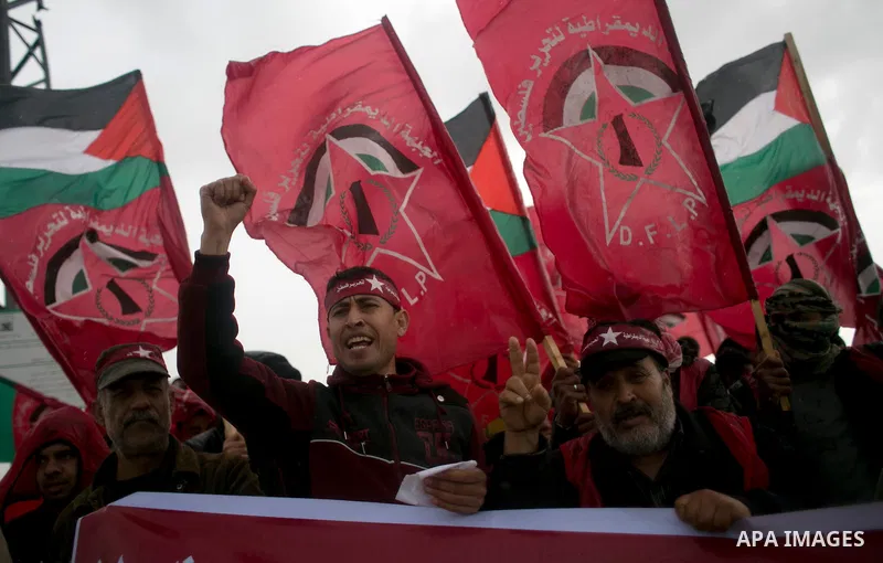 Palestinian supporters of the Democratic Front for the Liberation of Palestine (DFLP) shout slogans and hold flags of the movement during an anti-Israel protest marking the 47th anniversary of the DFLP establishment on F...
