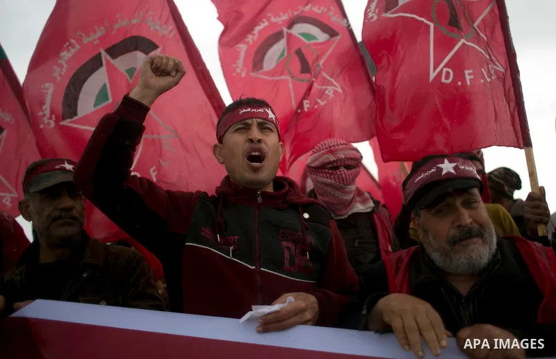 Palestinian supporters of the Democratic Front for the Liberation of Palestine (DFLP) shout slogans and hold flags of the movement during an anti-Israel protest marking the 47th anniversary of the DFLP establishment on F...