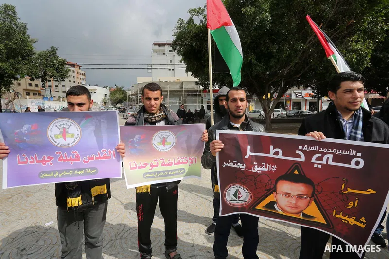Palestinians hold posters bearing a portrait of Palestinian journalist Mohammed al-Qiq who is imprisoned in an Israeli jail during a protest in support of his hunger strike in Gaza city on Feb. 23, 2016. Photo by Mohamme...