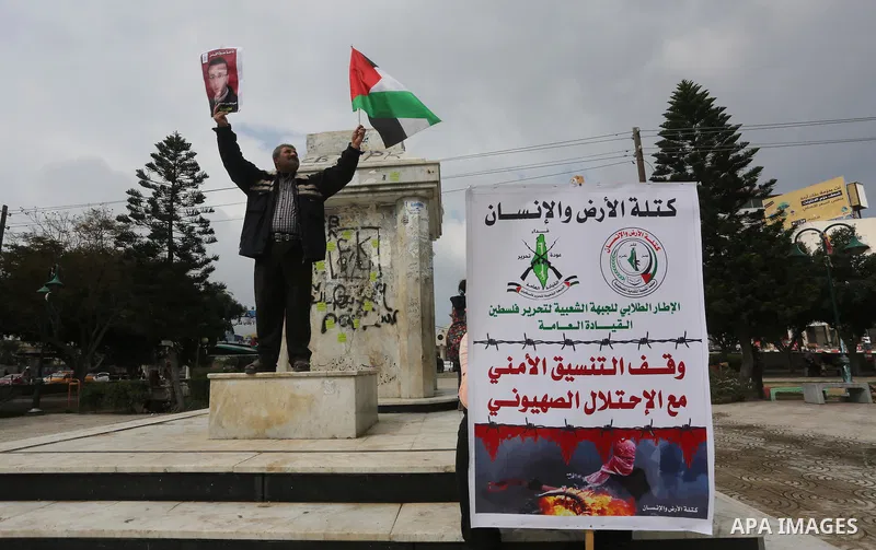 Palestinians hold posters bearing a portrait of Palestinian journalist Mohammed al-Qiq who is imprisoned in an Israeli jail during a protest in support of his hunger strike in Gaza city on Feb. 23, 2016. Photo by Mohamme...