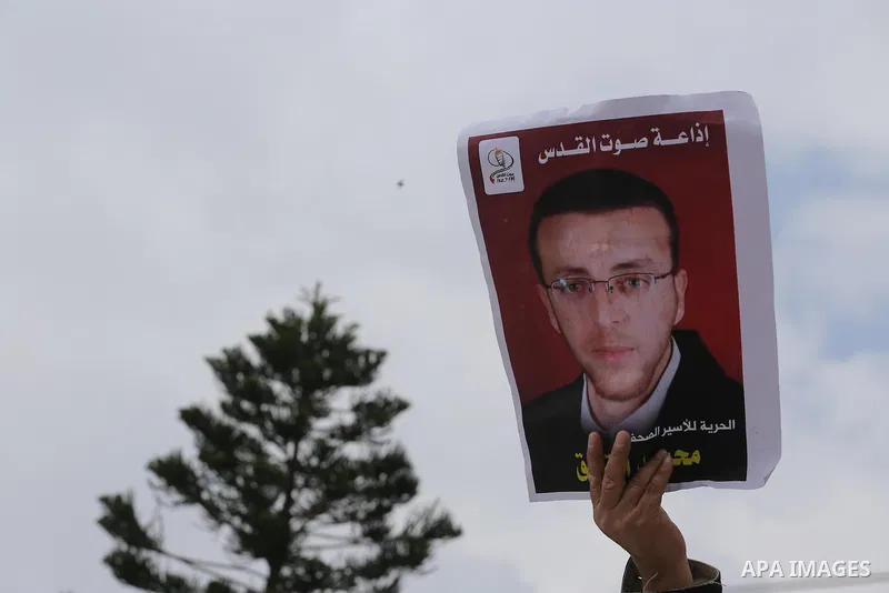 Palestinians hold posters bearing a portrait of Palestinian journalist Mohammed al-Qiq who is imprisoned in an Israeli jail during a protest in support of his hunger strike in Gaza city on Feb. 23, 2016. Photo by Mohamme...
