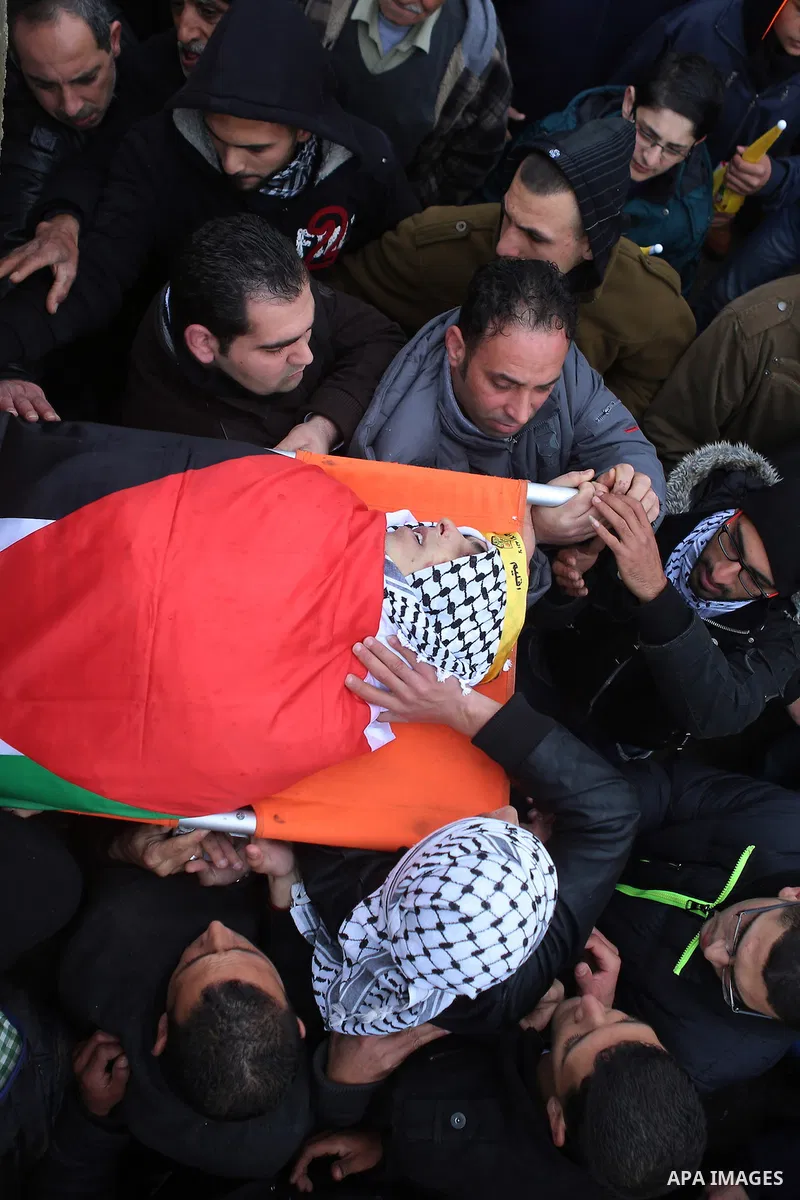 Palestinian mourners carry the body of one of two Palestinians, who the Israeli military said were fatally shot by Israeli police officers after they opened fire at them outside Jerusalem's walled Old City on February 14...